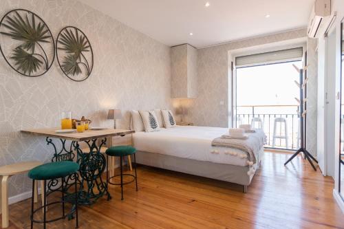 - une chambre avec un lit, une table et des chaises dans l'établissement Alfama Vintage Studio Apartment w/ RiverView - by LU Holidays, à Lisbonne
