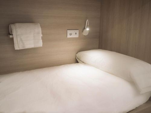 a bedroom with a white bed and towels on the wall at Santiago KM-0 in Santiago de Compostela