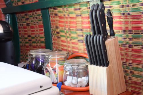 a group of knives sitting on a counter next to jars at De huifkar in Warstiens