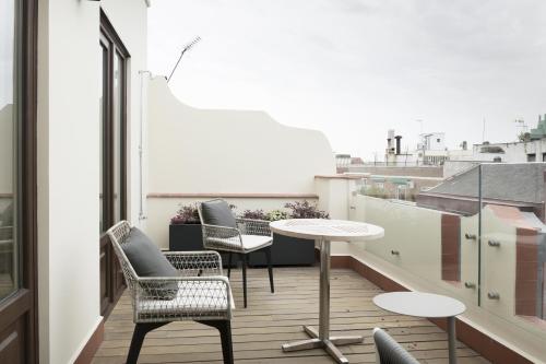a balcony with chairs and a table on a building at ICON Casona 1900 in Madrid