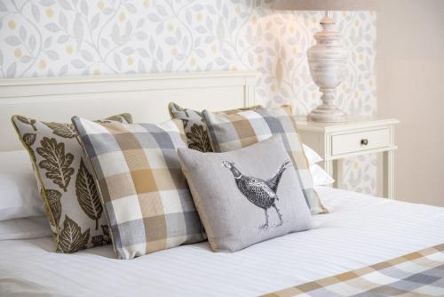 a bed with pillows and a chicken pillow on it at The King's Head in Thirlmere