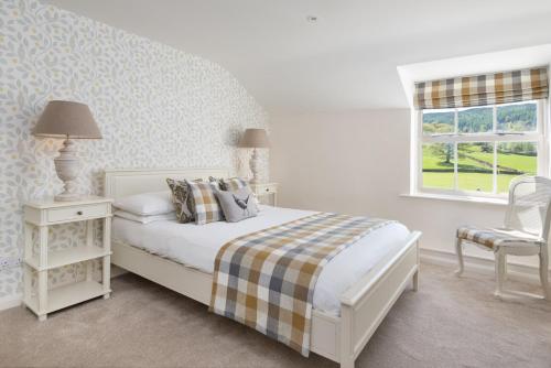 a white bedroom with a bed and a window at The King's Head in Thirlmere