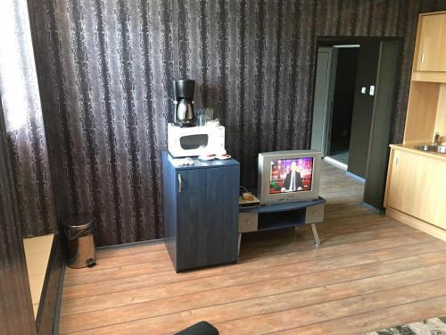 een kamer met een tv en een magnetron op een tafel bij Europe Dunav Apartment in Vidin