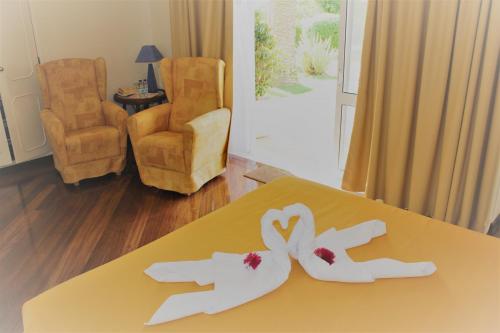 a table with two white hands and flowers on it at Quinta dos Oliveiras in Carvoeiro