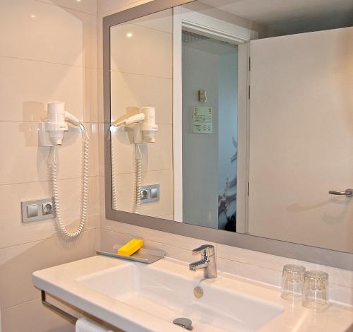een badkamer met een wastafel en een spiegel bij BQ Delfín Azul Hotel in Port d'Alcudia
