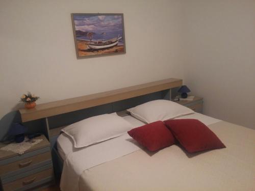 a bedroom with a bed and a painting on the wall at House Krk in Krk