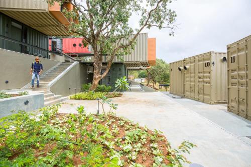 a man walking down a sidewalk next to a building at Zostel Plus Panchgani in Panchgani