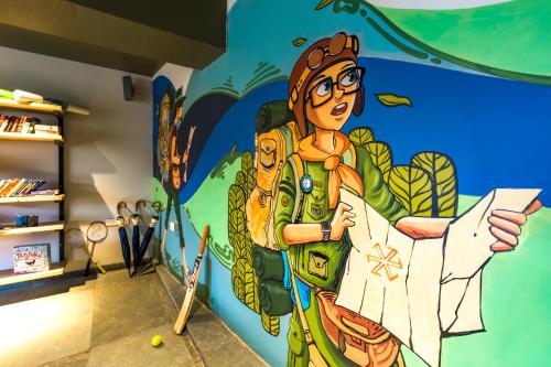a mural of a woman holding a piece of paper at Zostel Plus Panchgani in Panchgani