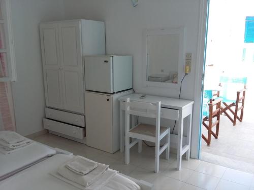cocina con nevera, mesa y escritorio en Galanis Place, en Antíparos