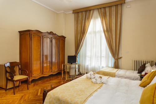 a bedroom with two beds with cats laying on them at Hotel Villa Maria in Sanremo