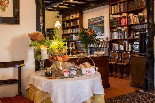 uma mesa numa sala com uma biblioteca com livros em Quinta de São Caetano - São Miguel Açores em Populo