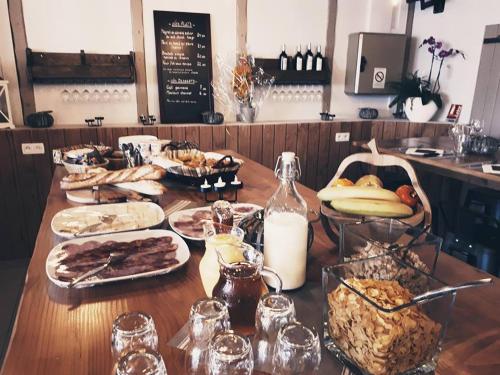 una mesa de madera con comida y bebidas. en Hotel Restaurant L'Escale, en Le Grau d'Agde
