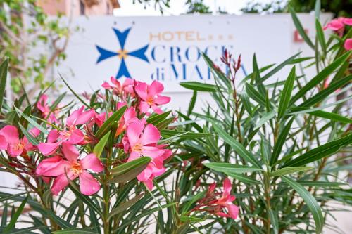 a bunch of pink flowers in front of a hotel sign at Hotel Croce Di Malta in Imperia