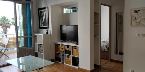 ein Wohnzimmer mit einem TV und einem Glastisch in der Unterkunft Nice Seaview Free Parking 4.Pers in Nizza
