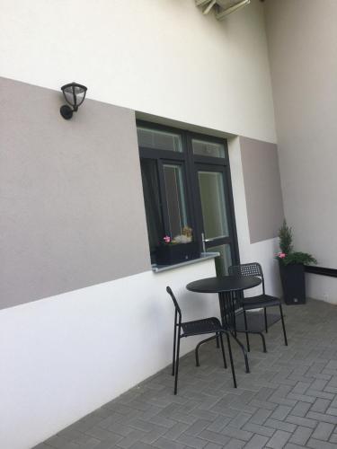 a patio with two chairs and a table and a window at Penzion U Hujňáků in Rohatec