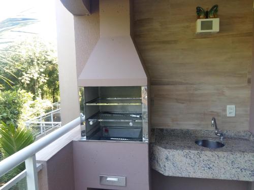 a kitchen with a sink on a balcony at ILHABELA PRAIA DO CURRAL Condômino VilaBela da Princesa in Ilhabela