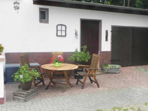 eine Terrasse mit einem Holztisch und 2 Stühlen in der Unterkunft Ferienwohnungen Fiedler in Neuhof