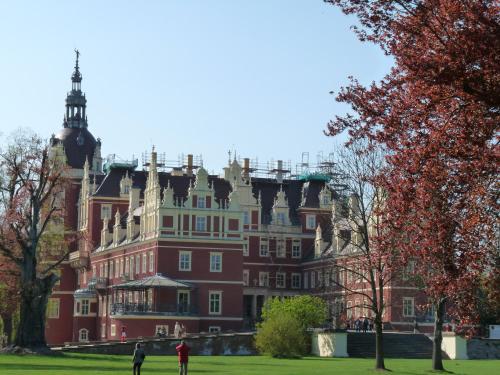 a large red building with people standing in front of it at Hotel Kristall in Weißwasser