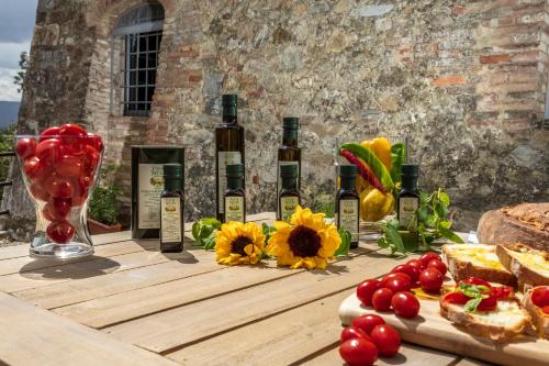 a table with bottles of wine and fruits and vegetables at Tenuta della Selva in Murlo
