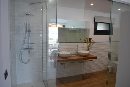 a bathroom with two sinks and a glass shower at Desconectate in Aldán