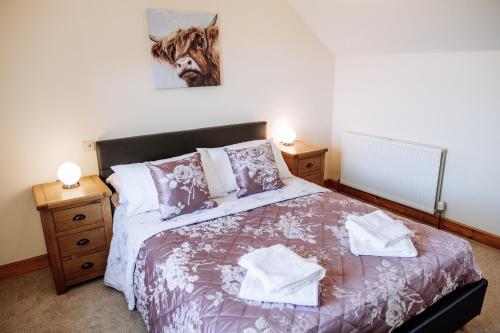 um quarto com uma cama e uma imagem de uma vaca na parede em Stockman's Cottage em Kirkcudbright