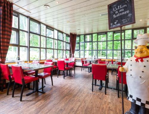 a giant teddy bear in a restaurant with tables and chairs at Bastion Hotel Heerlen in Heerlen