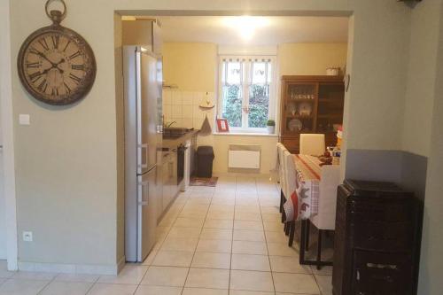 une cuisine avec une horloge sur le mur et une table dans l'établissement Le yellow, à La Bresse