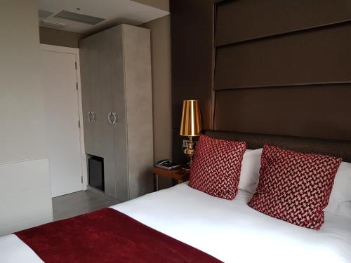 a bedroom with a large bed with red pillows at Hotel Art Santander in Santander