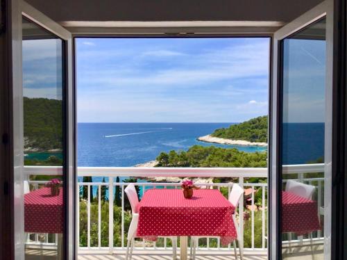 a balcony with a table and a view of the ocean at Apartments Marija Magdalena in Hvar