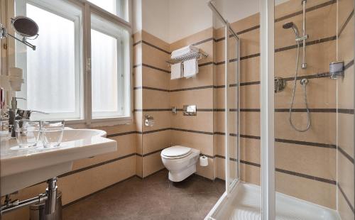 a bathroom with a shower and a toilet and a sink at EA Hotel Downtown in Prague