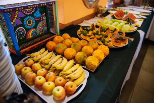 a table topped with plates of fruits and vegetables at Hotel Villa D'Angelo in Itatiba