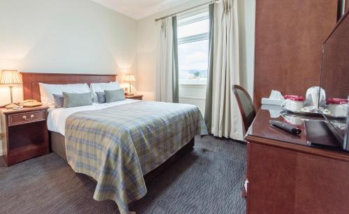 a hotel room with a bed and a desk at Ben Nevis Hotel & Leisure Club in Fort William