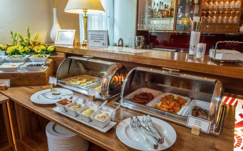 a buffet line with trays of food in a restaurant at EA Hotel Sonata in Prague