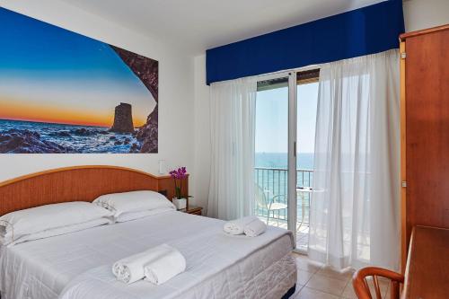 - une chambre avec un lit et une vue sur l'océan dans l'établissement Hotel Croce Di Malta, à Imperia