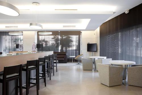 a restaurant with a bar with chairs and tables at Suittes Hotel in Algeciras