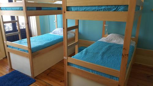 2 beliches num quarto com paredes azuis em CoolHostel em Porto