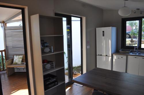 a kitchen with a table and a refrigerator at Ti Joli Caz en Bois in Saint-Gilles-les Hauts