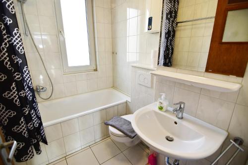 uma casa de banho com um lavatório, um WC e um chuveiro em Apartments Köln Gremberghofen em Colônia