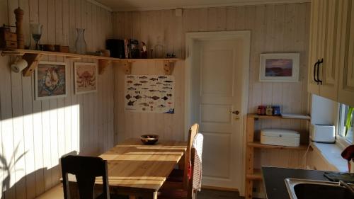 cocina con mesa de madera y comedor en The Blue House at the end of the World I, en Mehamn