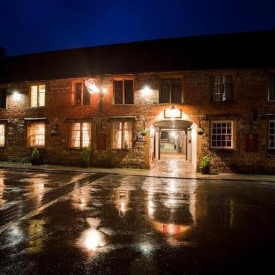 an empty street in front of a brick building at night at The New Inn in Cerne Abbas