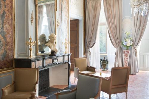 a living room with a statue and a table and chairs at Château de Fonscolombe in Le Puy-Sainte-Réparade