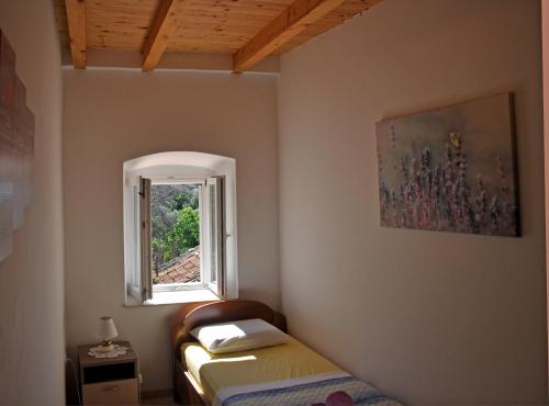 a small room with a bed and a window at Mediterranean stone house in Babino Polje