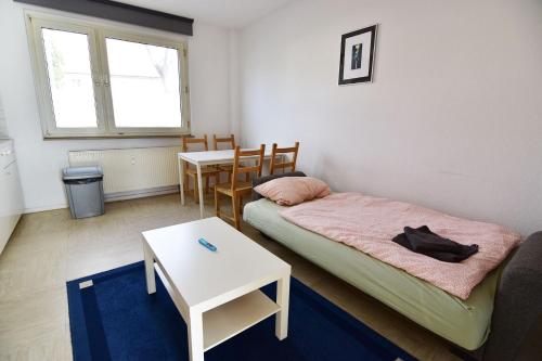 ケルンにあるApartments Köln Gremberghofenのベッドとテーブル付きの小さな部屋