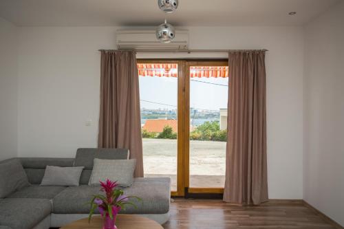 a living room with a couch and a large window at Losko in Solin