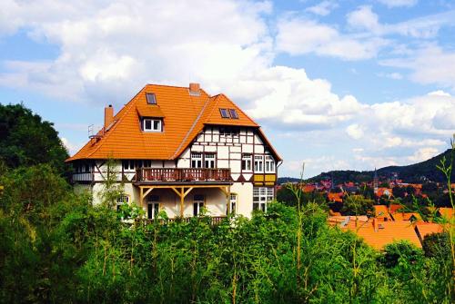 ein großes Haus mit orangefarbenem Dach in der Unterkunft Apartments Villa-Ratskopf Wernigerode in Wernigerode