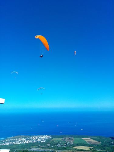 a kite flying in the sky over the ocean at Les bungalows de la kazouale in Saint-Leu