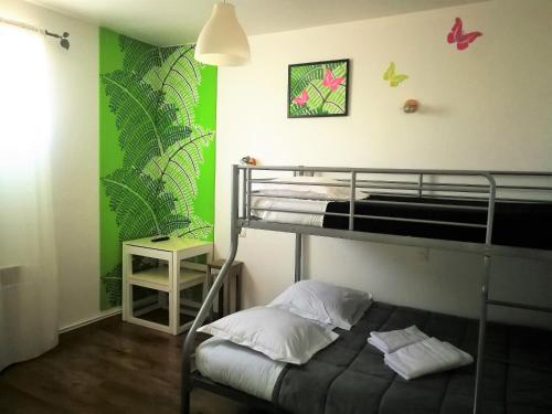 a bedroom with a bunk bed and a green wall at Terrasses de l'Aven in Orgnac-lʼAven
