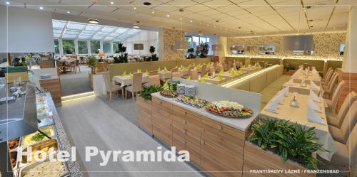a restaurant with tables and chairs in a cafeteria at Lázeňský hotel Pyramida in Františkovy Lázně
