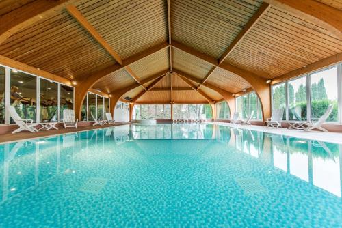 - une grande piscine avec des chaises dans un bâtiment dans l'établissement Ben Nevis Hotel & Leisure Club, à Fort William