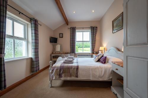 a bedroom with a bed and two windows at White Hart Inn in Bouth